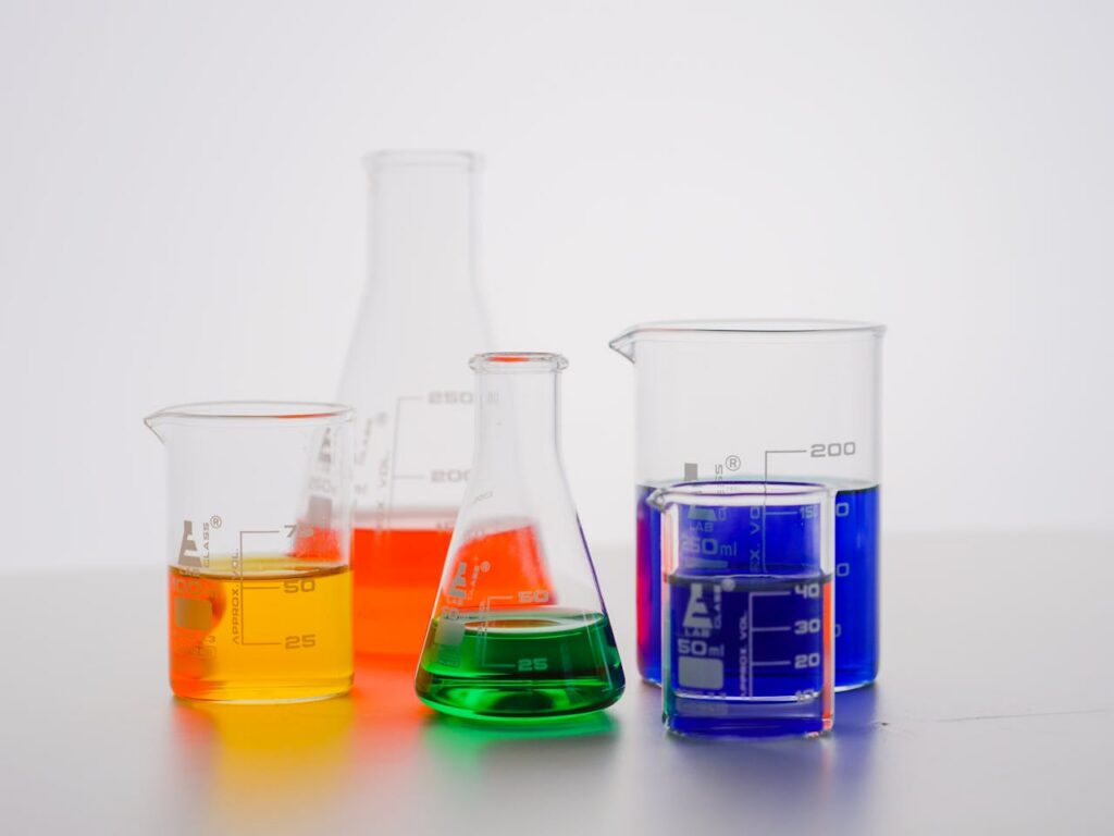 Close-up of laboratory beakers with colorful liquids used for experiments.